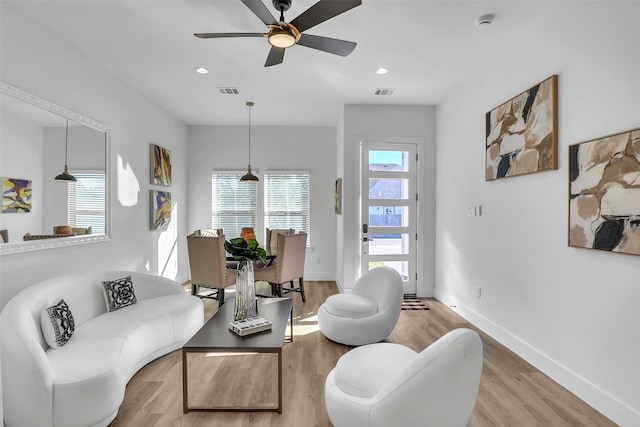 living room with ceiling fan and light hardwood / wood-style flooring