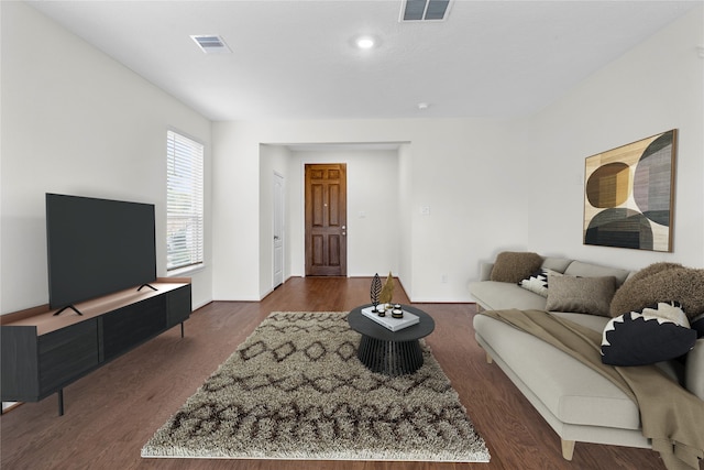 living room with dark wood-style floors and visible vents