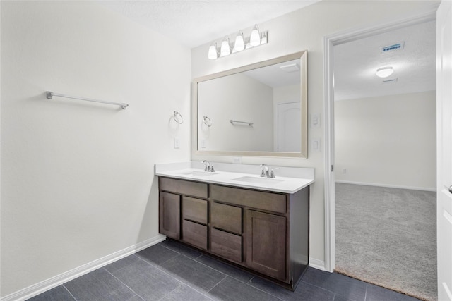 full bathroom with tile patterned flooring, a sink, baseboards, and double vanity