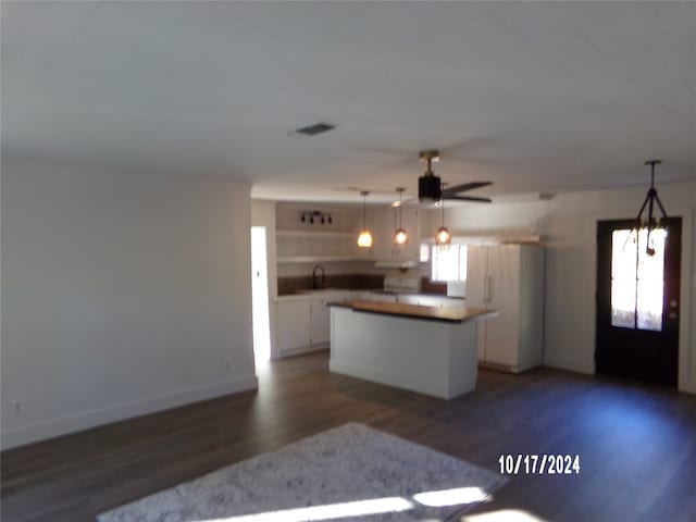 kitchen featuring a center island, decorative light fixtures, dark hardwood / wood-style flooring, white cabinetry, and ceiling fan