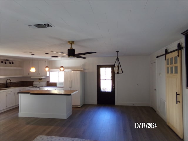 kitchen featuring white cabinetry, a barn door, dark hardwood / wood-style floors, and a wealth of natural light