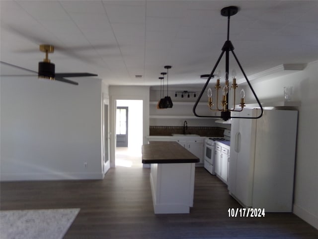 kitchen with fridge, dark hardwood / wood-style floors, white gas range oven, pendant lighting, and white cabinets