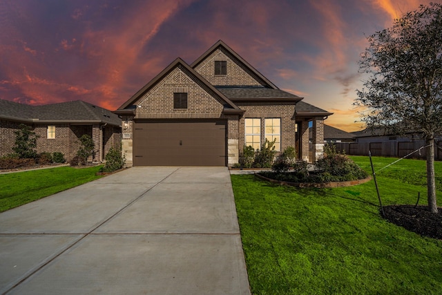 view of front of home with a garage and a lawn