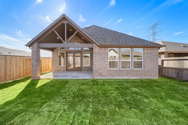 rear view of property featuring a patio, a yard, and french doors