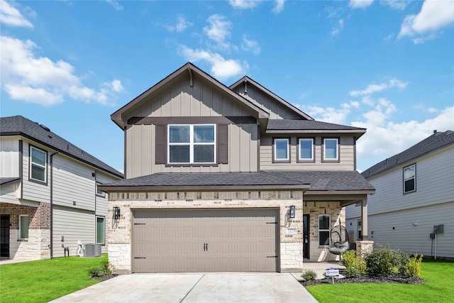 craftsman-style home with a garage, a front lawn, and central AC unit