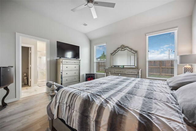 bedroom featuring ceiling fan, ensuite bath, vaulted ceiling, and light hardwood / wood-style floors