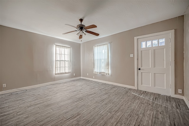 entrance foyer with a healthy amount of sunlight, light wood-type flooring, and ceiling fan