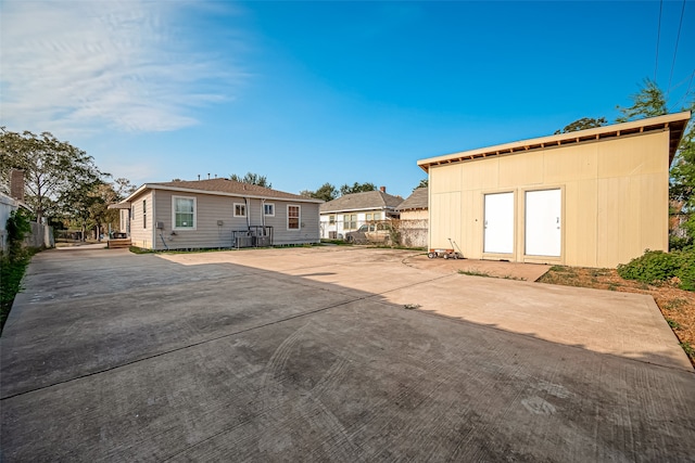 back of property with central air condition unit, a patio area, and a shed