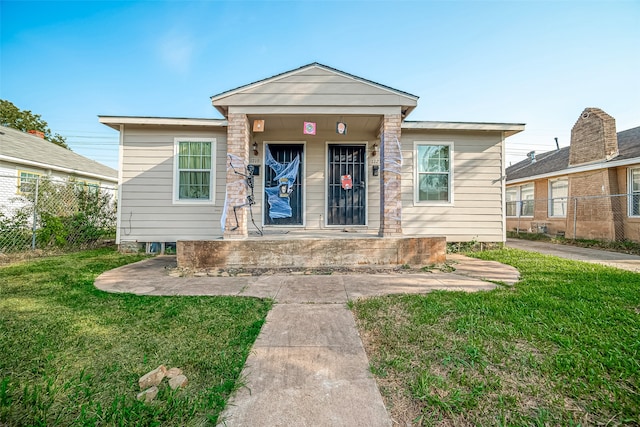 bungalow-style home with a front lawn