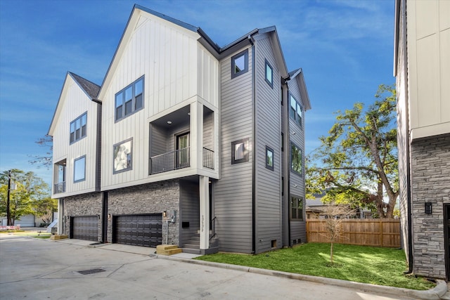 exterior space with a balcony, a garage, and a front lawn