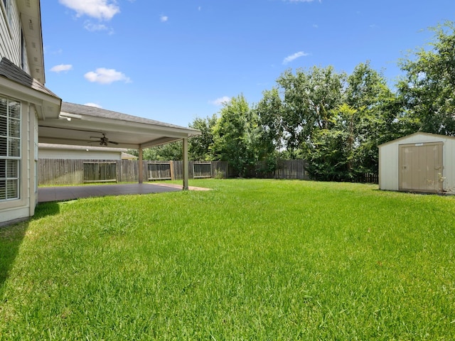 view of yard featuring ceiling fan and a storage shed