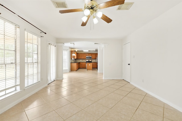 empty room with ceiling fan and light tile patterned floors