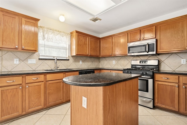 kitchen featuring a kitchen island, sink, appliances with stainless steel finishes, and tasteful backsplash