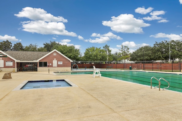 view of swimming pool featuring an in ground hot tub