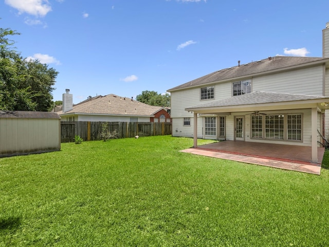 back of property featuring a lawn, a patio area, and a shed