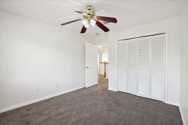 unfurnished bedroom featuring dark colored carpet, ceiling fan, and a closet