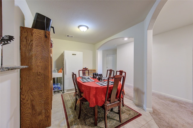 dining area featuring light tile patterned flooring and a textured ceiling