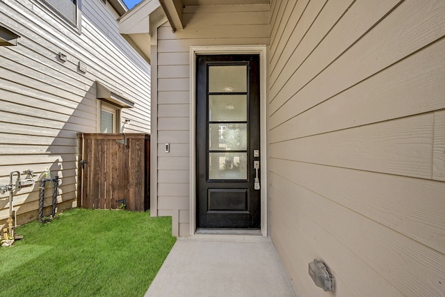 view of exterior entry with a lawn