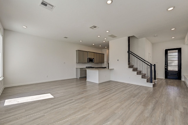 unfurnished living room with sink and light hardwood / wood-style flooring