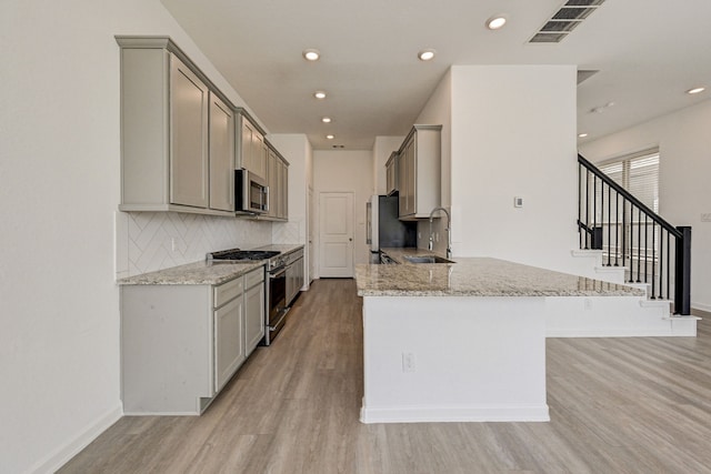 kitchen with gray cabinets, sink, appliances with stainless steel finishes, and light hardwood / wood-style floors