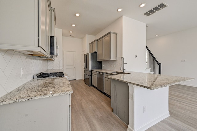 kitchen featuring gray cabinets, sink, appliances with stainless steel finishes, and light stone countertops