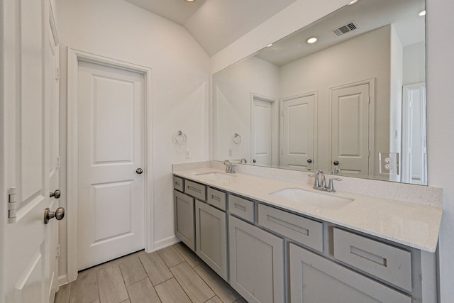 bathroom with vanity, vaulted ceiling, and hardwood / wood-style floors