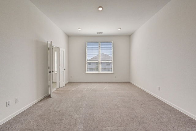 unfurnished room featuring light colored carpet