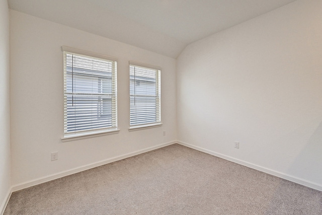 empty room with carpet and vaulted ceiling