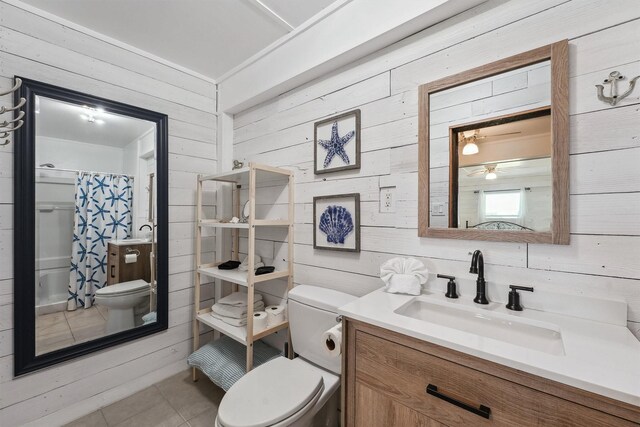 full bath with a ceiling fan, wooden walls, a shower with curtain, toilet, and tile patterned flooring