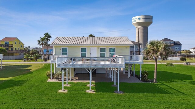 back of house with metal roof, a yard, and a deck