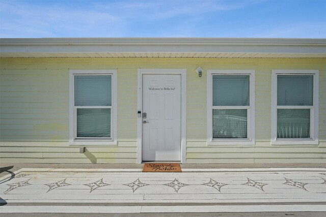 view of exterior entry with a wooden deck