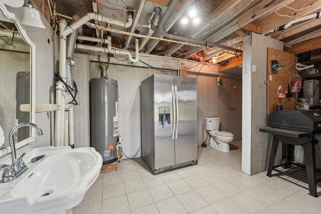 interior space featuring light tile patterned flooring, gas water heater, a sink, and stainless steel fridge with ice dispenser