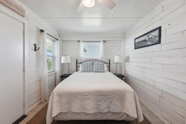 bedroom with wooden walls and ceiling fan