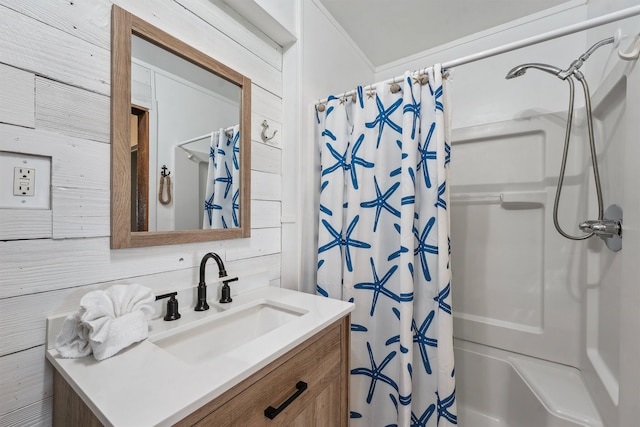 bathroom with vanity, wooden walls, and shower / bathtub combination with curtain