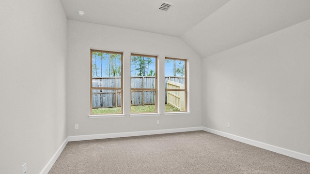 spare room with vaulted ceiling and carpet floors