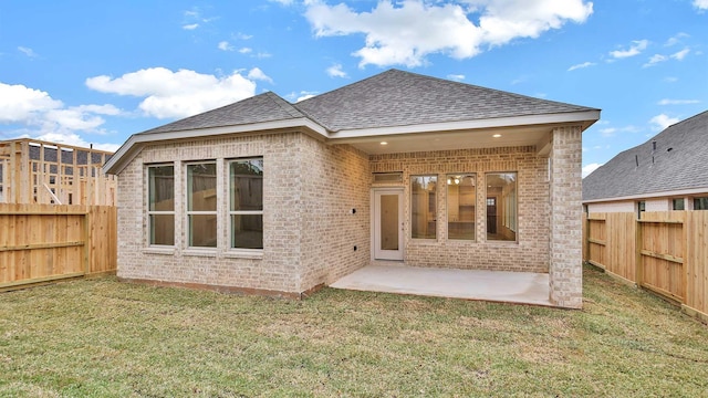 back of property with a patio and a lawn