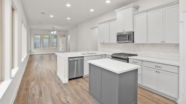 kitchen featuring sink, kitchen peninsula, a kitchen island, and stainless steel appliances