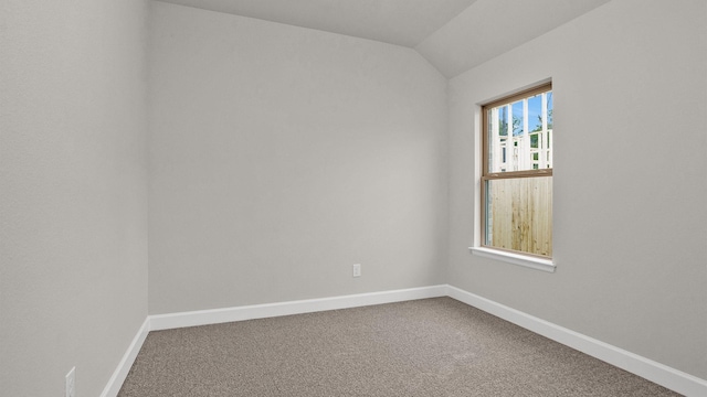 carpeted empty room featuring lofted ceiling