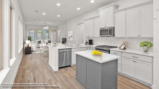 kitchen with kitchen peninsula, a kitchen island, stainless steel appliances, and decorative backsplash