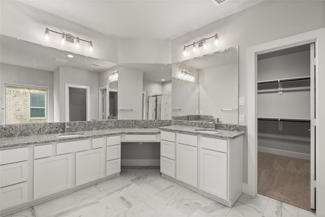 bathroom with vanity and a shower with shower door