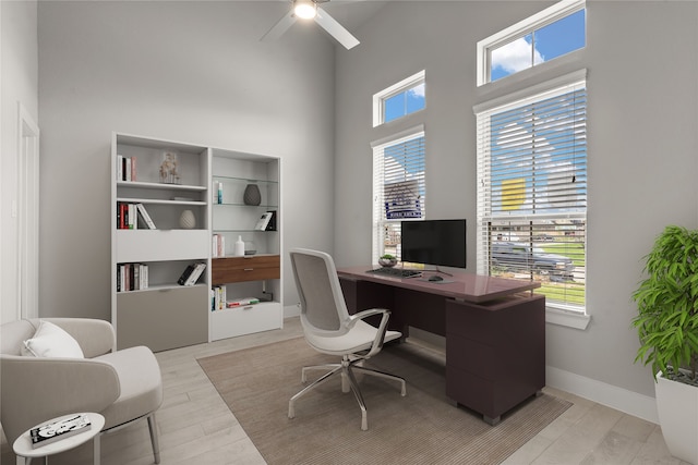 office featuring a wealth of natural light, a high ceiling, and light hardwood / wood-style flooring