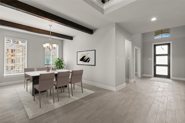 dining space with light hardwood / wood-style flooring, a chandelier, and beam ceiling