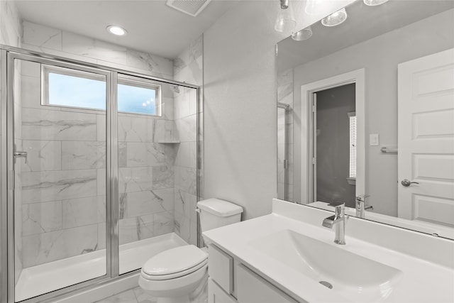 bathroom featuring vanity, toilet, and a shower with shower door