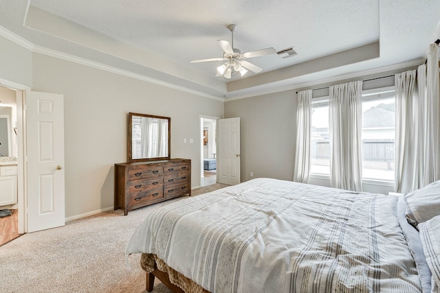 bedroom featuring a textured ceiling, a tray ceiling, ceiling fan, crown molding, and light colored carpet