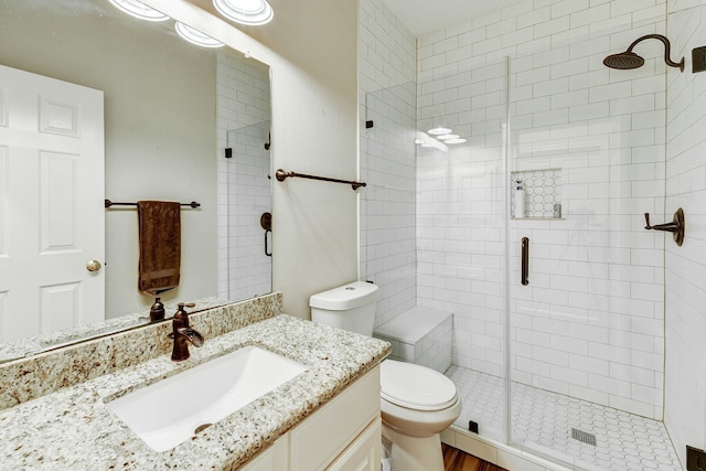 bathroom featuring vanity, toilet, hardwood / wood-style flooring, and walk in shower