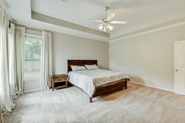 bedroom featuring ceiling fan, carpet, and a tray ceiling