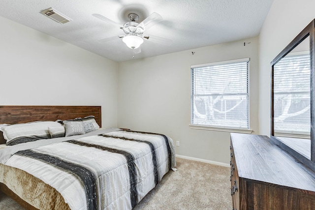 carpeted bedroom with a textured ceiling and ceiling fan