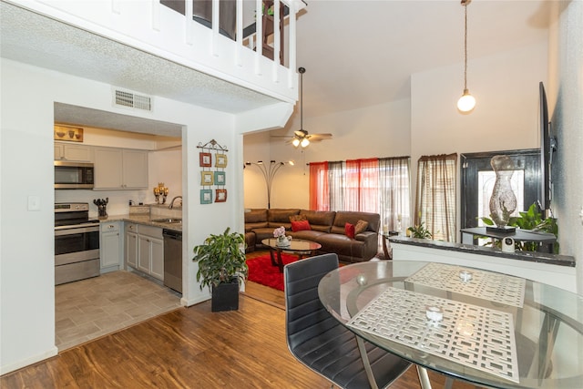 interior space featuring a textured ceiling, hardwood / wood-style flooring, sink, and ceiling fan