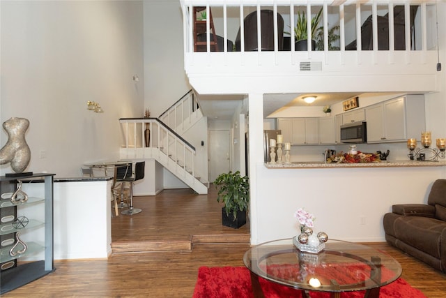 12638 Newbrook Dr, Houston, TX 77072 - living area featuring stairway, visible vents, a towering ceiling, and wood finished floors