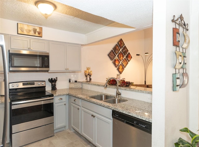12638 Newbrook Dr, Houston, TX 77072 - kitchen with a sink, a textured ceiling, backsplash, light stone countertops, and appliances with stainless steel finishes
